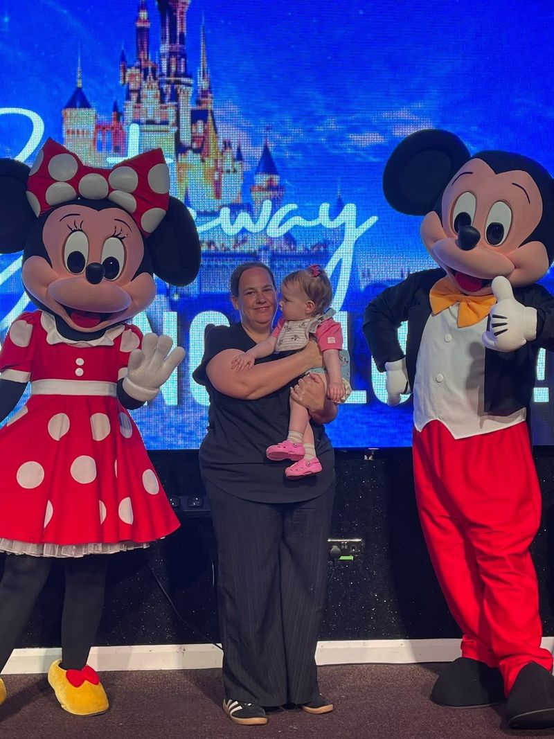 Two look-alike mascots with a mum and her baby on stage